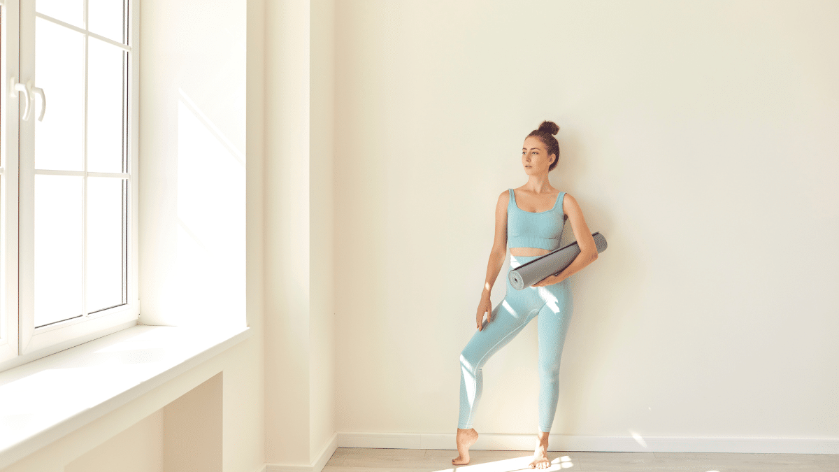 pilates au mur : personne réalisant des exercices de Pilates en s'appuyant contre un mur