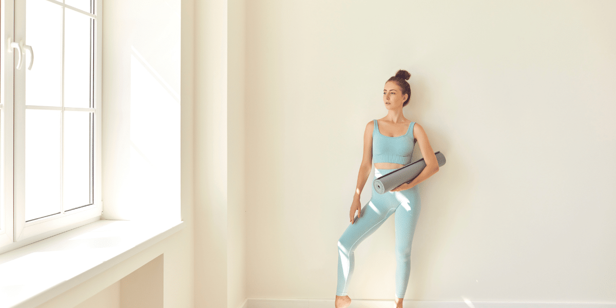 pilates au mur : personne réalisant des exercices de Pilates en s'appuyant contre un mur